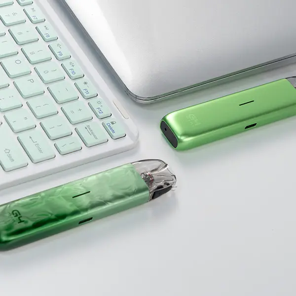 uwell-caliburn-g4-mini-kit-26.jpg Uwell Caliburn G4 Mini Pod Kit in Grün neben Laptop-Tastatur, Lifestyle-Aufnahme