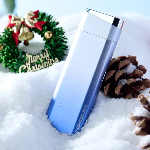 Innokin Klypse Plus Pod Kit in Blau-Silber Farbverlauf, Lifestyle-Foto auf Schnee mit Weihnachtsdeko