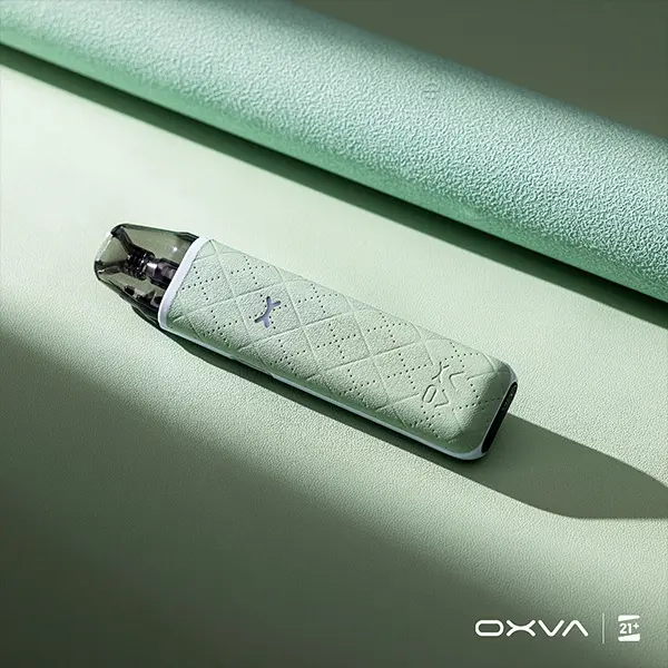 Oxva Xlim Go Pod Kit in Mintgrün – Pod-System liegend auf grünem Untergrund mit eingesetztem Pod