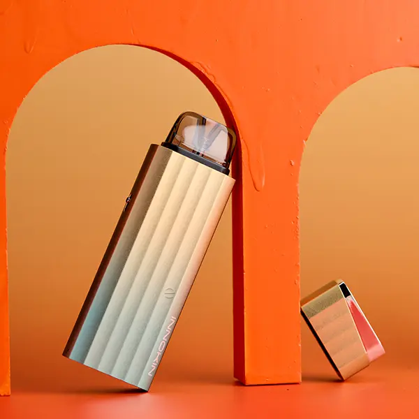 Innokin Klypse Plus Pod Kit in cremeweiß-orange mit abgenommener Pod-Kappe auf orangefarbenem Hintergrund